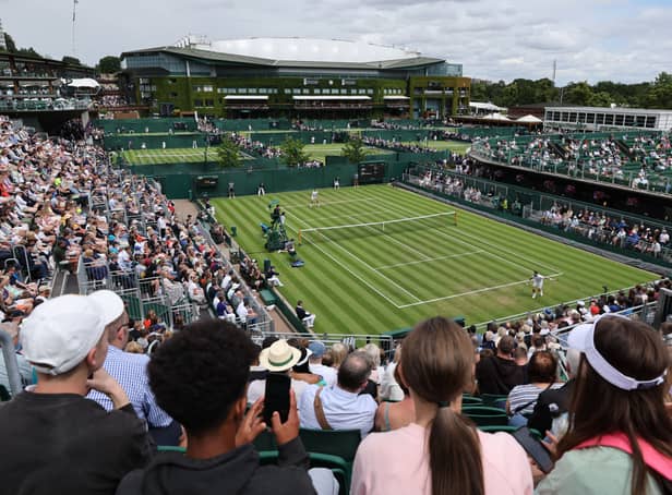 <p>People watch a game on court 2 on the first day of the 2022 Wimbledon Championships (Pic: AFP via Getty Images)</p>