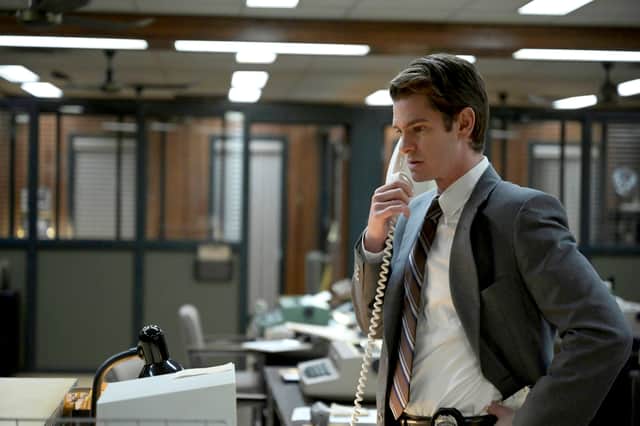 Andrew Garfield as Detective Jed Pyre, wearing a grey suit and answering a phone call in a police precinct bullpen (Credit: Michelle Faye/FX)