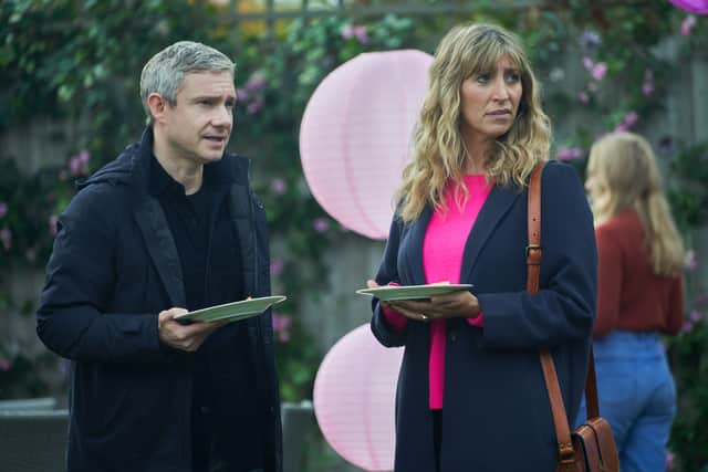 Martin Freeman as Paul and Daisy Haggard as Ava, stood in a garden holding cake at a child’s birthday party in an episode of Breeders (Credit: Sky/FX)