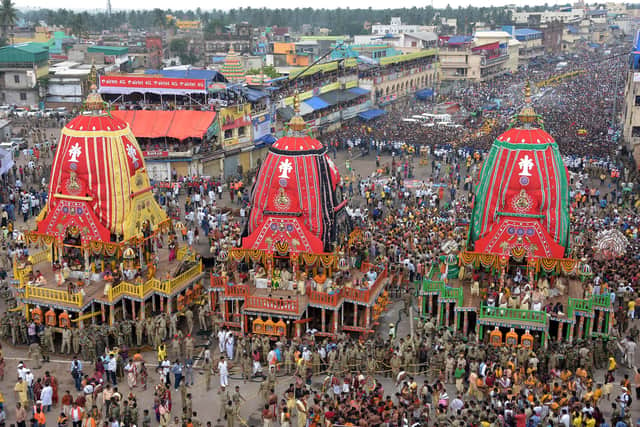 Devotees gather around chariots as they wait to pull them during the annual Hindu festival Rath Yatra or chariot procession in Puri 