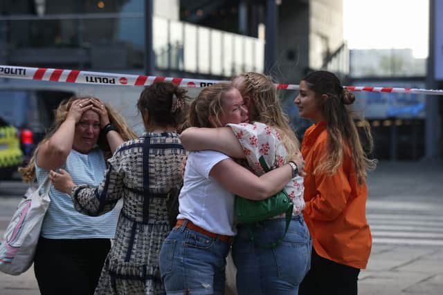 People embrace as police evacuate the scene (Ritzau Scanpix/AFP via Getty Images)
