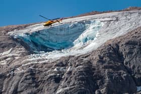 A rescue helicopter flies over the glacier that collapsed on the mountain of Marmolada, the highest in the Dolomites (Photo: PIERRE TEYSSOT/AFP via Getty Images)