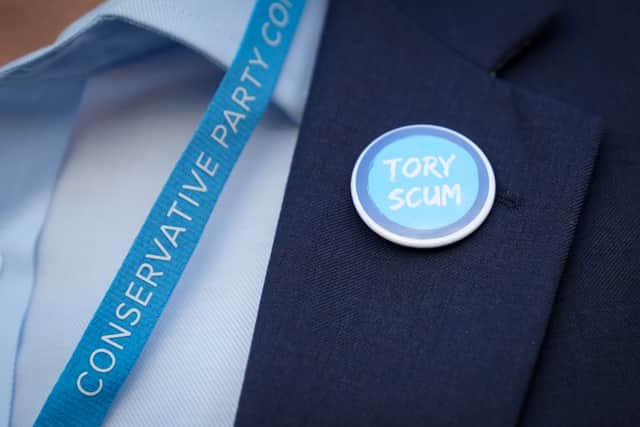 A Conservative delegate wears a “Tory Scum” lapel badge during the 2021 Conservative Party Conference in Manchester (Pic: Getty Images)