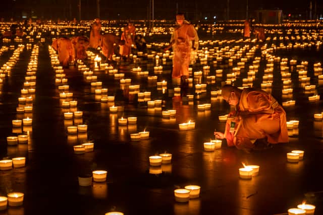  Buddhist monks light thousands of candles during Asalha Puja Day celebration at Wat Phra Dhammakaya Buddhist temple on the outskirt of Bangkok on July 24, 2021