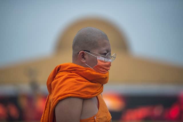 A Buddhist monk walks past the Dhammakaya cetiya, while preparing for Asalha Puja Day celebration at Wat Phra Dhammakaya Buddhist temple on the outskirt of Bangkok on July 24, 2021