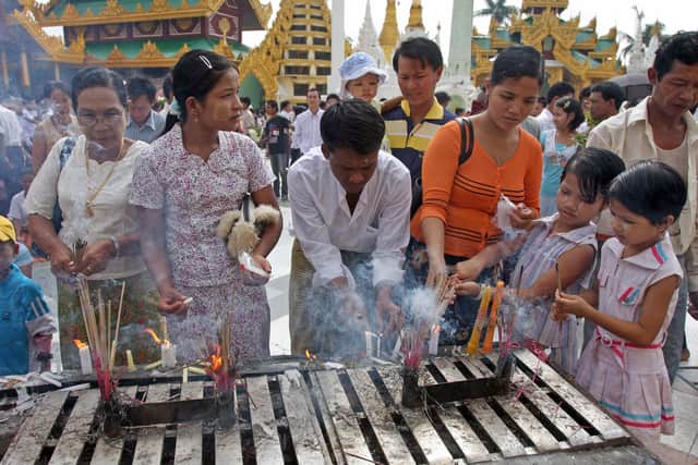 Buddhist devotees light candles at Shwedagon Pagoda in downtown Yangon on July 17, 2008