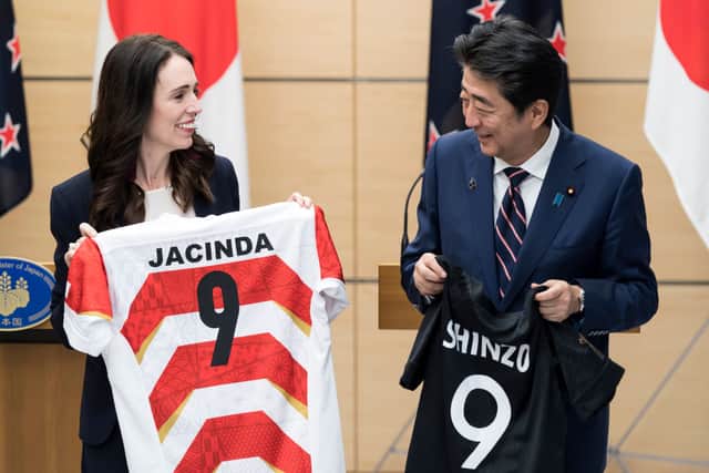 New Zealand Prime Minister Jacinda Ardern (L) and Japan’s then-Prime Minister Shinzo Abe (R) hold jerseys bearing their names after a joint press conference on September 19, 2019 in Tokyo (Photo by Tomohiro Ohsumi - Pool/Getty Images)
