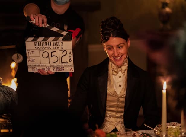 <p>A behind the scenes image of Suranne Jones on the Gentleman Jack set, in costume smiling next to a clapperboard (Credit: BBC/Lookout Point/HBO/Aimee Spinks)</p>