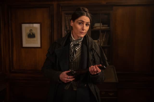 Suranne Jones as Anne Lister, holding a gun and looking directly into the camera (Credit: BBC/Lookout Point/HBO/Aimee Spinks)