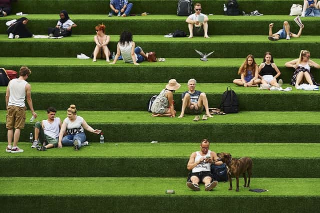 Members of the public enjoy the warm weather in central London on July 1, 2015 (Photo by NIKLAS HALLE’N/AFP via Getty Images)