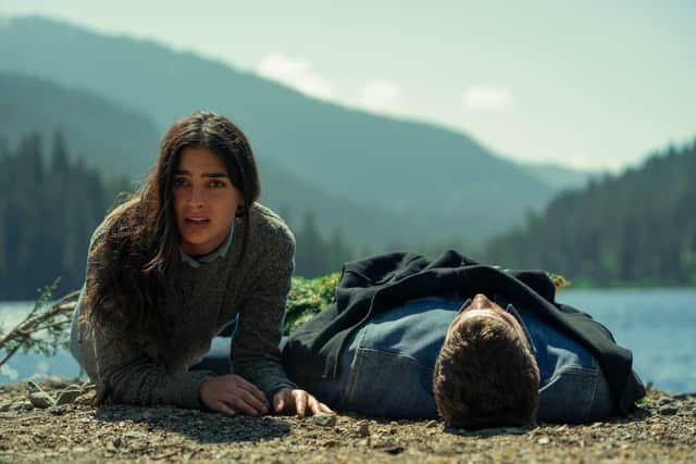 Melissa Barrera as Liv and Austin Stowell as Sam, washed up on the beach and panicking (Credit: Ricardo Hubbs/Netflix)