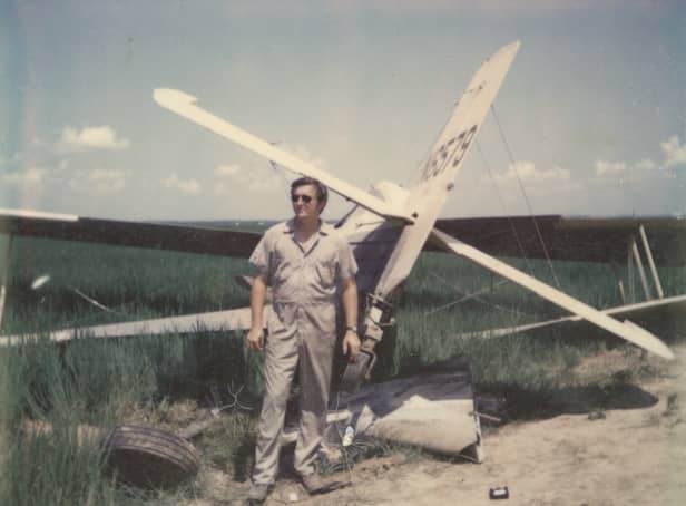 <p>Gary Betzner with a crashed plane</p>