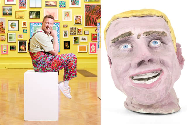 L-R: Comedian Joe Lycett, wearing floral dungarees and smiling, sat on a white art display plinth in the Royal Academy. The walls are yellow and covered in framed paintings; a clay bust of a man’s head, smiling. It has been painted, with blonde hair and blue eyes  (Credit: BBC Studios/Richard Ansett; Joe Lycett)