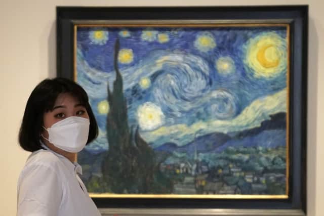 A woman stands near a painting by Vincent Van Gogh, " The Starry Night" as the Museum of Modern Art (MoMA) reopens its doors to the public on August 27, 2020 in New York (Photo by TIMOTHY A. CLARY/AFP via Getty Images)