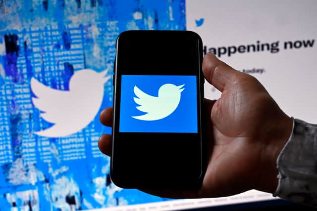 In this photo illustration, a phone screen displays the Twitter logo on a Twitter page background, in Washington, DC, on April 26, 2022. (Photo by Olivier DOULIERY / AFP) (Photo by OLIVIER DOULIERY/AFP via Getty Images)