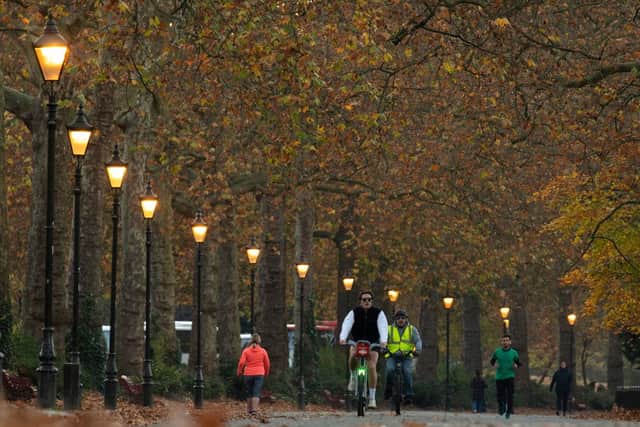 People make their way along the path past trees displaying autumnal colours in Battersea Park in south London on November 23, 2021 (Photo by JUSTIN TALLIS/AFP via Getty Images)