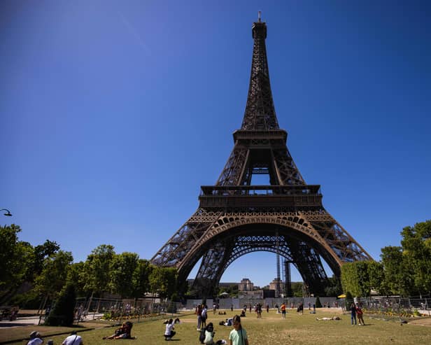 People walk on the Champ de Mars near the Eiffel Tower in Paris on July 8, 2022. (Photo by Sameer Al-DOUMY / AFP) (Photo by SAMEER AL-DOUMY/AFP via Getty Images)