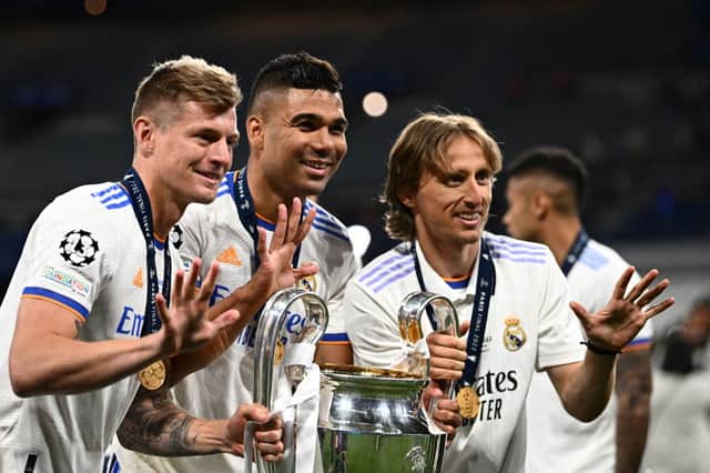 (From L) Real Madrid’s German midfielder Toni Kroos, Real Madrid’s Brazilian midfielder Casemiro and Real Madrid’s Croatian midfielder Luka Modric pose with the trophy after winning the UEFA Champions League final football match between Liverpool and Real Madrid at the Stade de France in Saint-Denis, north of Paris, on May 28, 2022. (Photo by ANNE-CHRISTINE POUJOULAT/AFP via Getty Images)