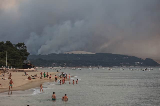 Tourists on the beach in Moulleau can see the smoke from the wildfire in La Teste-de-Buch, France (Pic: AFP via Getty Images)