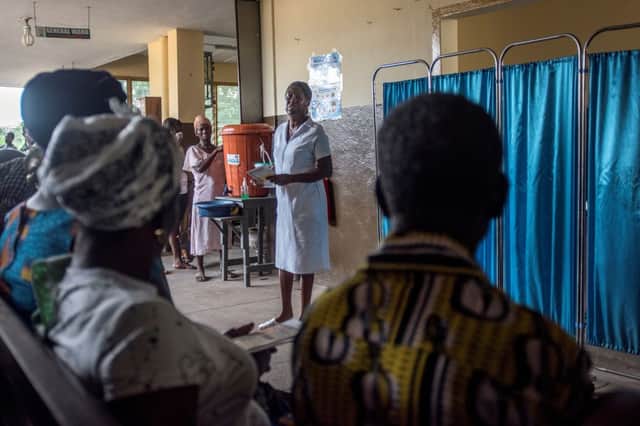 A nurse speaks to patients at Ewim Polyclinic in Cape Coast, Ghana, on April 30, 2019 (Photo by CRISTINA ALDEHUELA/AFP via Getty Images)