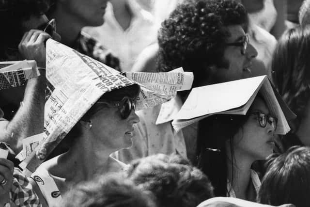 25 June 1976:  Spectators at Wimbledon protect themselves from the sun wearing newspaper hats and books on their heads (Getty Images)