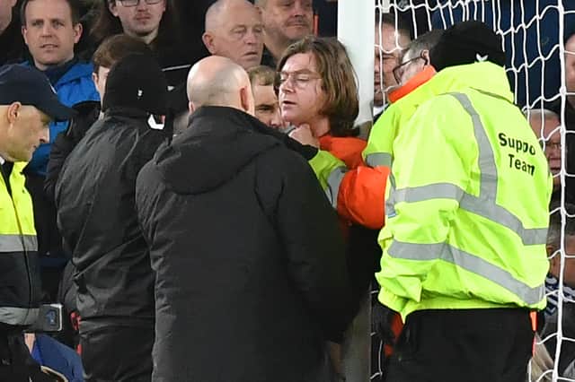 Security teams attempt to remove a Just Stop Oil protester from the goalposts at Goodison Park. (Credit: Getty Images)