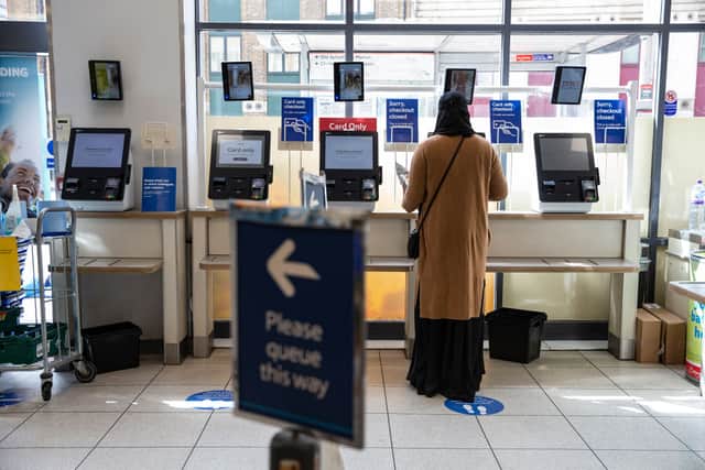 A woman uses a self-checkout at a Tesco  (Photo by Hollie Adams/Getty Images)