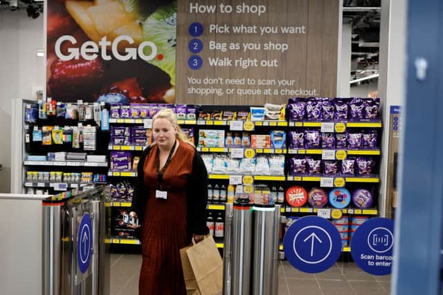 A customer carries the purchases as they leave from Tesco (Photo by TOLGA AKMEN/AFP via Getty Images)