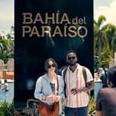 Cristin Milioti as Emma and William Jackson Harper as Noah, posing for a photo in front of a sign reading ‘Bahia del Paraiso’ (Credit: Peacock)