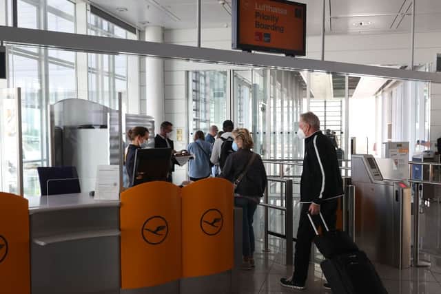 Passengers wait to board a Lufthansa flight (Photo by Alexander Hassenstein/Getty Images)