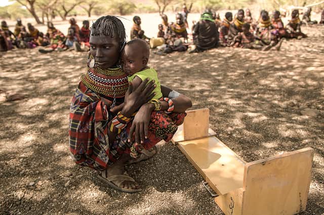 A mother holding her son waits to be taken care of, in Purapul village, Loiyangalani area of Kenya (AFP via Getty Images)