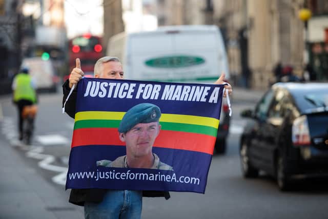 A supporter of British Sergeant Alexander Blackman holds up a banner outside the Royal Courts of Justice. (Photo by Jack Taylor/Getty Images)