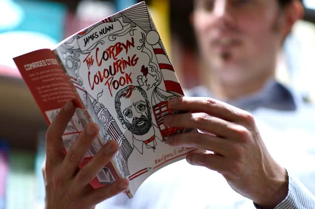 An person in London reads a copy of “The Corbyn Colouring Book” (Pic: Getty Images)