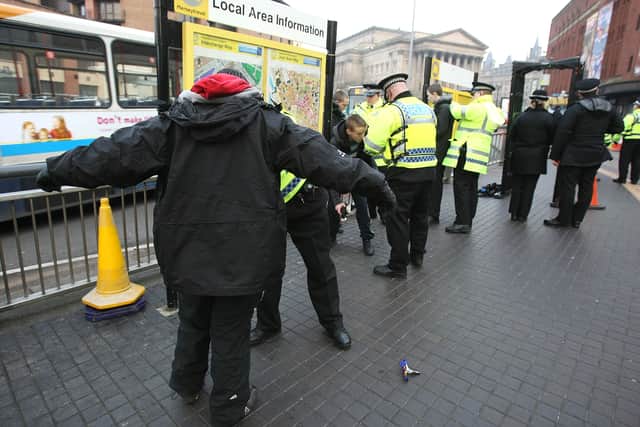 Police officers, combating potential knife-crime, stop and search people arriving in Liverpool by bus for traditional celebrations ahead of the festive period on 21 December, 2007, Liverpool, England