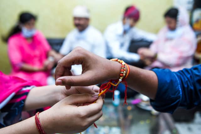 A sister ties a 'Rakhi,' a sacred thread, on her brother's wrist on the occasion of Raksha Bandhan festival, which celebrates the bonds between sisters and brothers