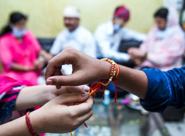 <p>A sister ties a 'Rakhi,' a sacred thread, on her brother's wrist on the occasion of Raksha Bandhan festival, which celebrates the bonds between sisters and brothers</p>