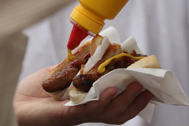 A patron puts mustard on their sausages (Pic: Getty Images)