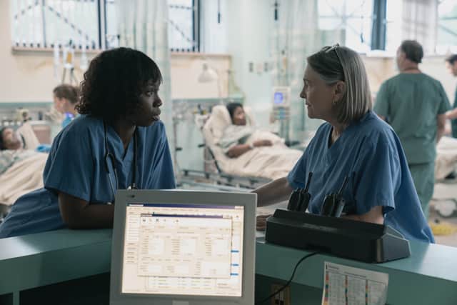 Adepero Oduye as Karen Wynn and Cherry Jones as Susan Mulderick, speaking to each other from adjacent sides of a corner desk. In the background, patients lie on hospital beds (Credit: Apple TV+)