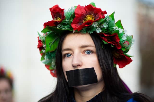 A woman with tape over her mouth. (Photo by Kena Betancur / AFP) (Photo by KENA BETANCUR/AFP via Getty Images)
