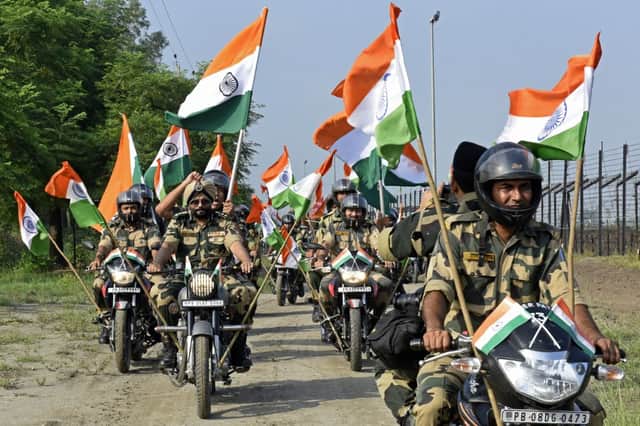 Indian Border Security Force soldiers take part in a motorbike rally along a border fence carrying India’s national flags as part of celebrations ahead of the 75th anniversary of country’s independence at an India-Pakistan border outpost (Photo: NARINDER NANU/AFP via Getty Images)