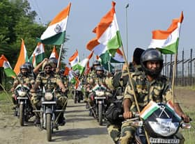 Indian Border Security Force soldiers take part in a motorbike rally along a border fence carrying India’s national flags as part of celebrations ahead of the 75th anniversary of country’s independence at an India-Pakistan border outpost (Photo: NARINDER NANU/AFP via Getty Images)
