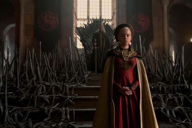 Milly Alcock as young Rhaenyra Targaryen, the Iron Throne and her father looming large behind her (Credit: HBO)