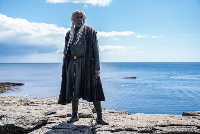Steve Toussaint as Lord Corlys Velaryon, the Sea Snake. He’s standing on the rocks, the clear blue sea behind him (Credit: HBO)