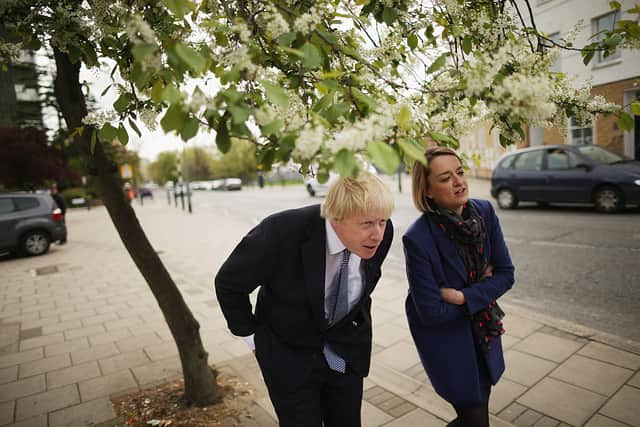 Boris Johnson, at the time London Mayor, ducks below tree branches while being interviewed by Laura Kuenssberg on May 1, 2015 (Photo by Chip Somodevilla/Getty Images)