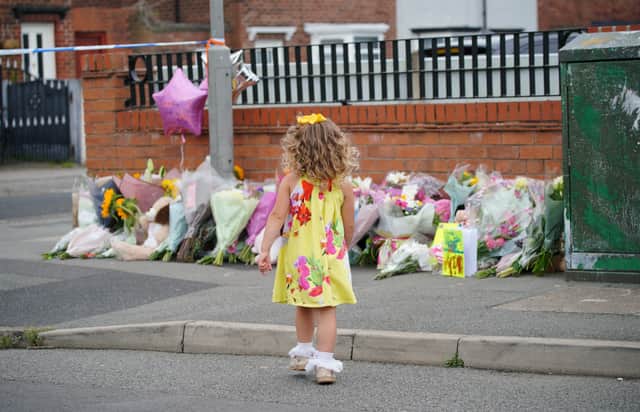 A young girl lays a tribute in Kingsheath Avenue, Knotty Ash, Liverpool, where nine-year-old Olivia Pratt-Korbel was fatally shot on Monday night. The people of Liverpool have been urged to turn in the masked gunman who killed Olivia as he chased his intended target into her home. Picture date: Wednesday August 24, 2022.