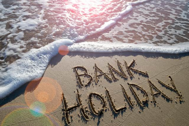 Bank Holiday message handwritten on the smooth sand of an empty beach with an oncoming wave (lazyllama - stock.adobe.com)