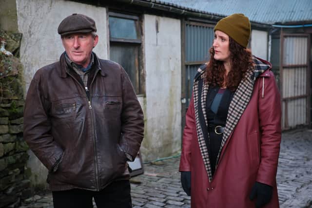 Adrian Dunbar as Alex Ridley and Bronagh Waugh as DI Carol Farman, wrapped up warm on a cobbled alleyway (Credit: ITV)