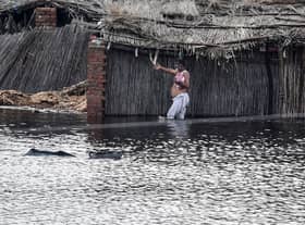 A resident wades across a flooded area after heavy monsoon rains on the outskirts of Sukkur, Sindh province, on August 27, 2022. - Thousands of people living near flood-swollen rivers in Pakistan's north were ordered to evacuate on August 27 as the death toll from devastating monsoon rains neared 1,000 with no end in sight. (Photo by Asif HASSAN / AFP) (Photo by ASIF HASSAN/AFP via Getty Images)