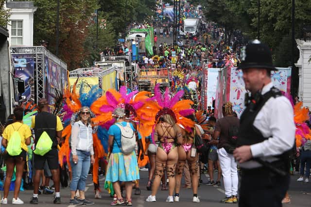 A police officer stands on duty as performers in costume take part in the carnival (Getty Images)