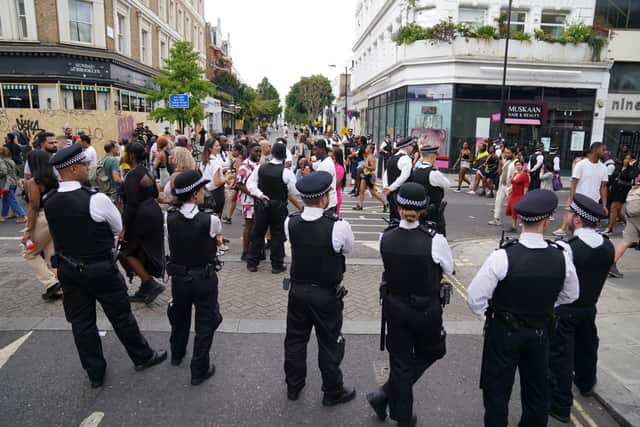 Police officers looking at revellers during the Notting Hill Carnival in London, which returned to the streets for the first time in two years after it was thwarted by the pandemic. Credit: PA